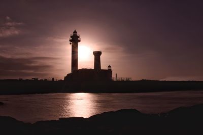Silhouette of tower at seaside during sunset
