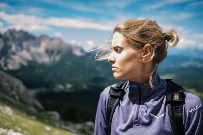 Close-up of young woman looking away against sky