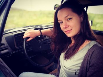 Portrait of young woman sitting in car