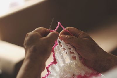 Cropped hands of person weaving wool