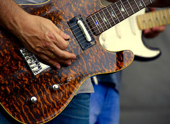 Midsection of man playing guitar