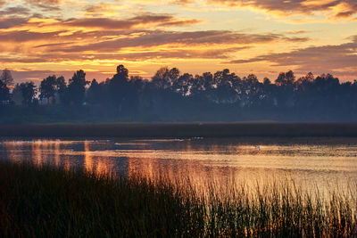 Scenic view of lake against orange sky