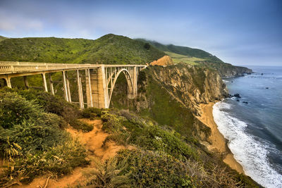 Arch bridge over sea against sky