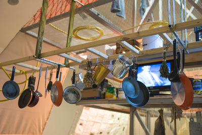 Low angle view of cooking utensils hanging from rack