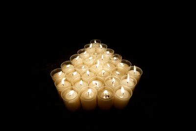 Close-up of illuminated candle against black background