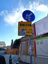 Low angle view of road sign against sky