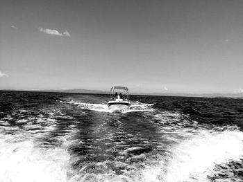 Boat sailing in sea against sky