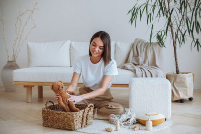 A young mother cleans up children's toys at home