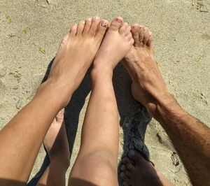 Low section of family on sand at beach