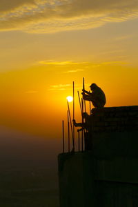 Silhouette man against orange sky during sunset