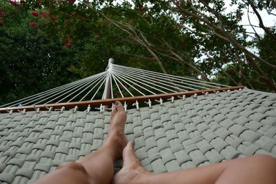 Low section of people relaxing on hammock