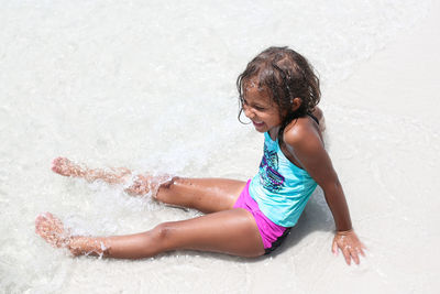 High angle view of girl enjoying on shore at beach during sunny day