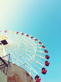 Low angle view of ferris wheel against clear blue sky