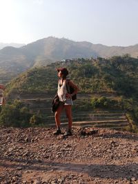 Full length of woman standing against mountains and sky