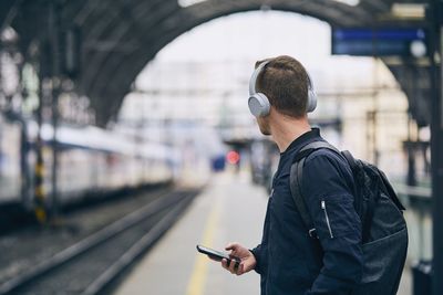 Man standing at railroad station platform