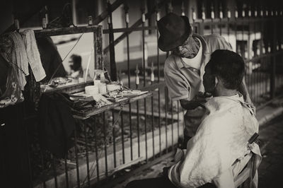 Barber shaving beard of customer