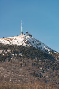 Building on mountain against clear blue sky