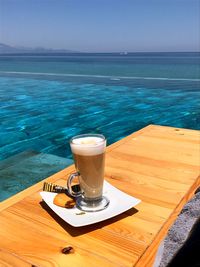 Close-up of coffee on table by sea