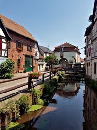 Canal amidst buildings against sky