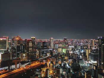 Illuminated cityscape against sky at night