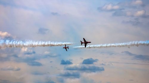 Low angle view of airplanes flying in sky during sunset