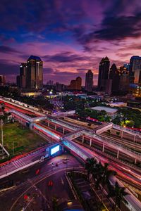 High angle view of light trails on road against buildings at night