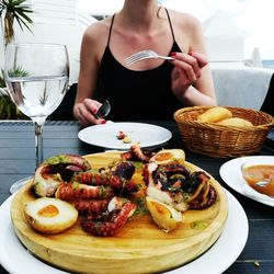 Midsection of woman having food in restaurant