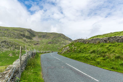 Mountain road against cloudy sky