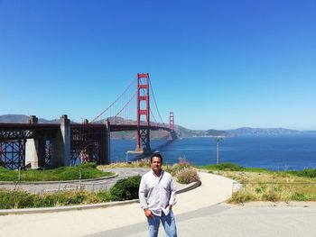 Portrait of man standing against golden gate bridge over bay 