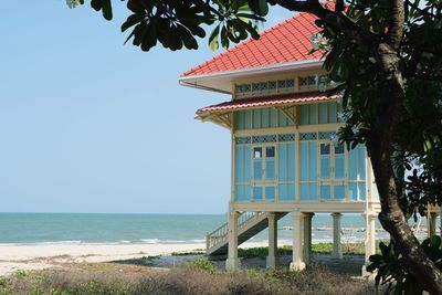 Built structure on beach by sea against sky