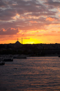 Scenic view of sea against dramatic sky during sunset