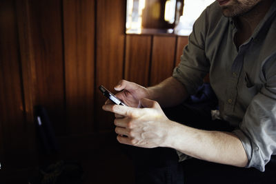 Midsection of man using mobile phone