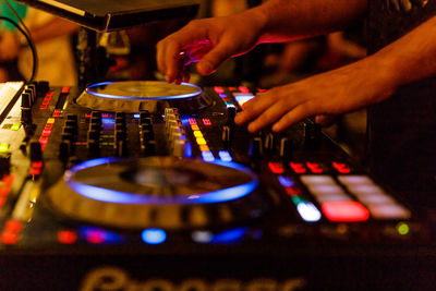 Cropped hands mixing music in nightclub