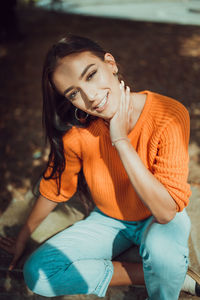 Portrait of smiling young woman sitting outdoors