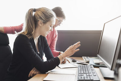 Businesswomen discussing at computer desk in office