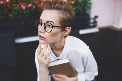 Portrait of young woman holding book