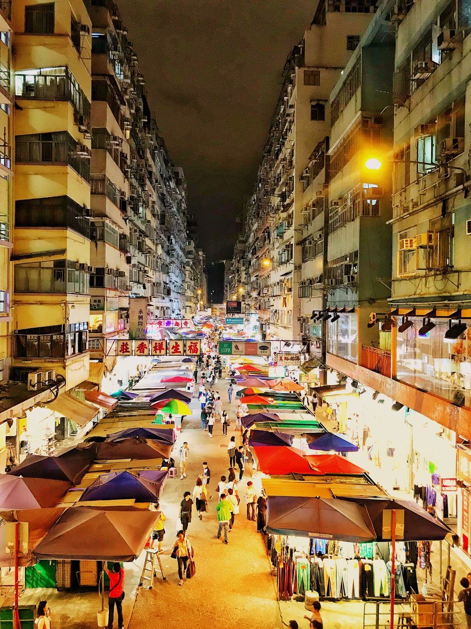 architecture, building exterior, city, built structure, group of people, market, crowd, real people, illuminated, night, street, market stall, large group of people, building, city life, women, incidental people, lifestyles, men, outdoors, street market