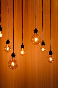 Illuminated light bulbs hanging from ceiling