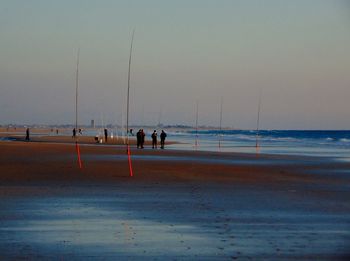 People on beach against sky