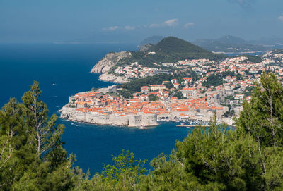 High angle view of townscape by sea against sky