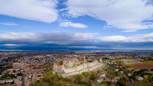 Aerial view of townscape against cloudy sky