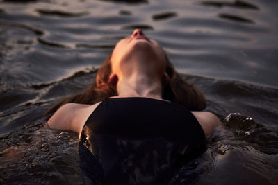 Rear view of woman lying on beach