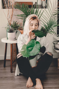 Young woman sitting on chair at home