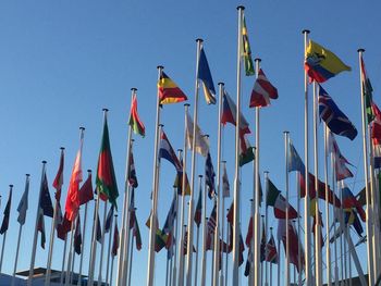 Low angle view of flags against clear sky