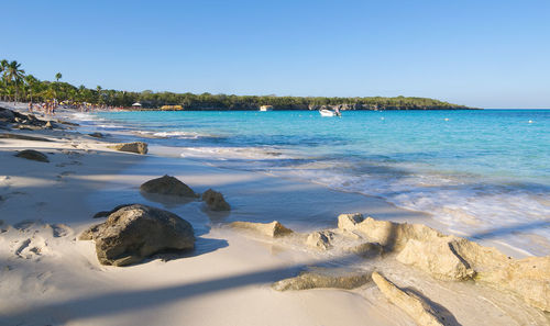 Scenic view of beach against clear blue sky