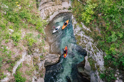 People on rock formation amidst water