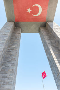 Low angle view of flag flags against clear sky