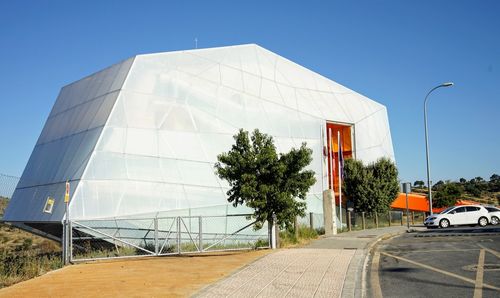 Road by building against clear sky