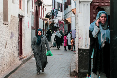 Full length of people walking on street in city