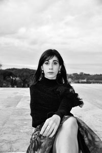 Portrait of woman sitting against sky